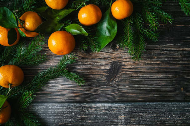 tangerines and fir branches on wooden boards for a Christmas card - Фото, изображение
