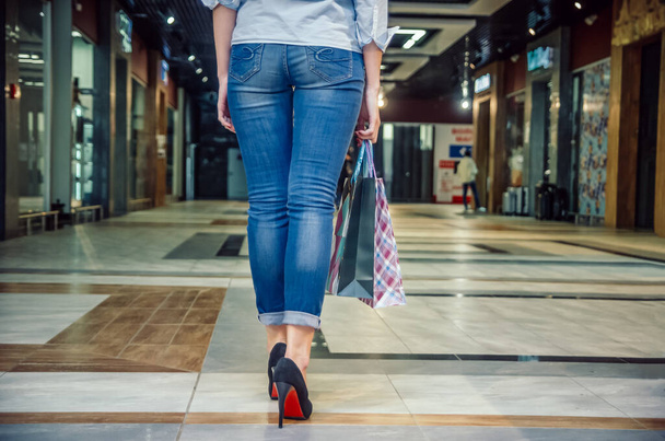 В магазинах, дівчата з довгими ногами в черевиках з мішками в торговому центрі. Погляд ззаду - Фото, зображення