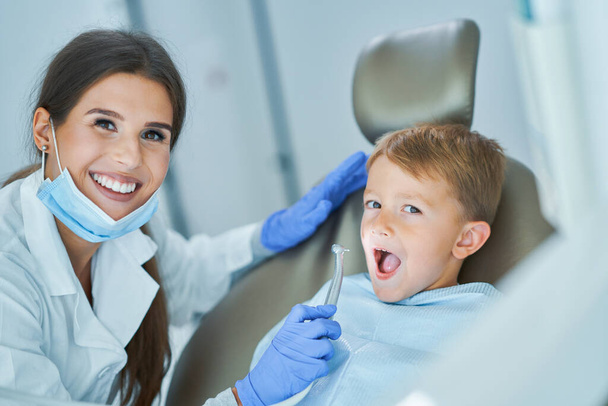 Kisfiú és női fogorvos a fogorvosi rendelőben. - Fotó, kép