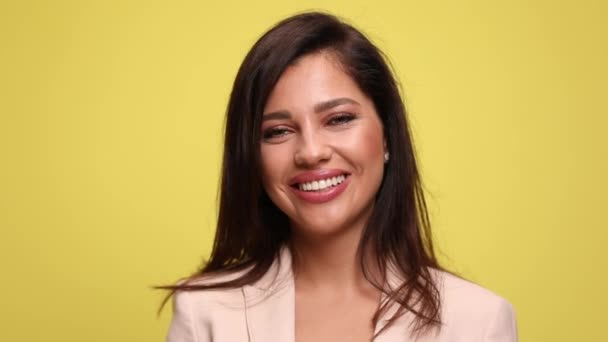 νεαρή ελκυστική επιχειρηματίας υψώνει το τρόπαιό της και μια γροθιά στον αέρα και γιορτάζει επιτυχίες σε κίτρινο φόντο - Πλάνα, βίντεο