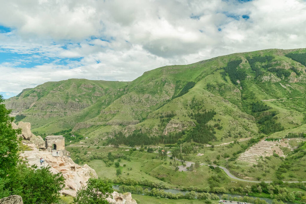 Vista panorámica de la ciudad monasterio cueva Vardzia. Vista desde el monasterio hasta el valle del río y pendientes verdes en un soleado día de verano - Foto, imagen