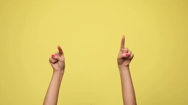 twee armen wijzen naar de camera, geven een duim omhoog en vieren succes op gele achtergrond - Video