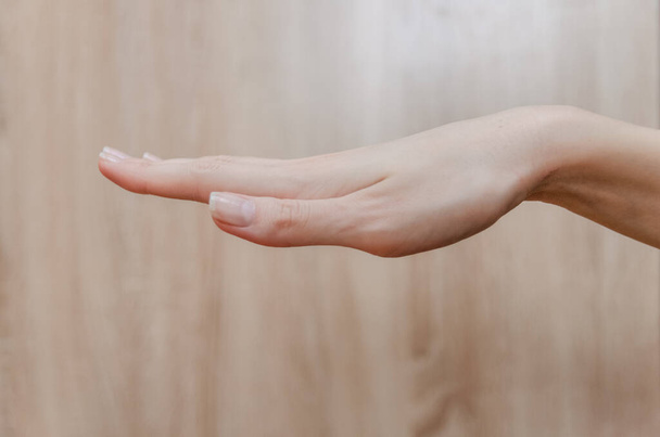 umgekehrte weibliche Handfläche auf Holzgrund - Foto, Bild
