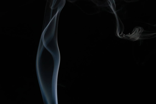 Abstract smoke background with copy space on black background. Blue-white smoke rising from the incense stick - Foto, Imagem