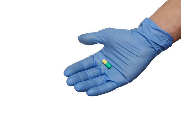 de pillen in handen in blauwe handschoenen - Foto, afbeelding