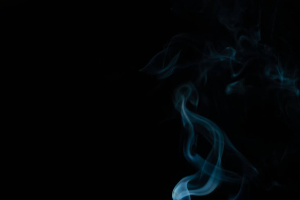 Schöner abstrakter blauer Rauch mit Kopierraum auf schwarzem Hintergrund. Rauchhintergrund für Kunstdesign oder Zeichnung. Abstrakte Abbildung des Rauchs - Foto, Bild