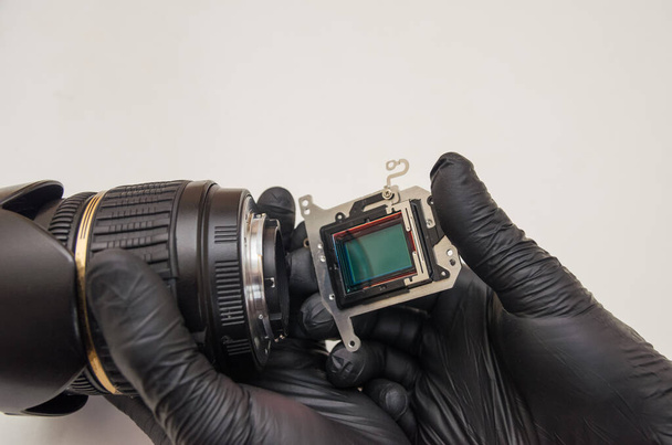 The lens and the matrix in the hands of the master in repair - Photo, Image