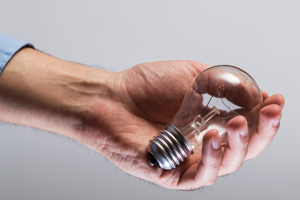 Hand with light bulb - Фото, изображение