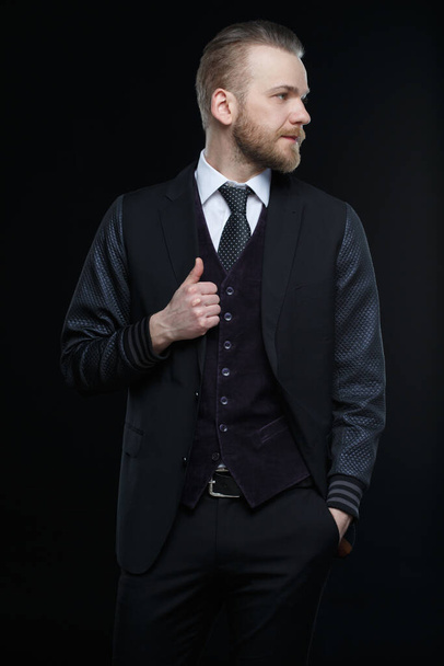 Representative man with a beard in a three-piece suit isolated on a black background. - Foto, afbeelding