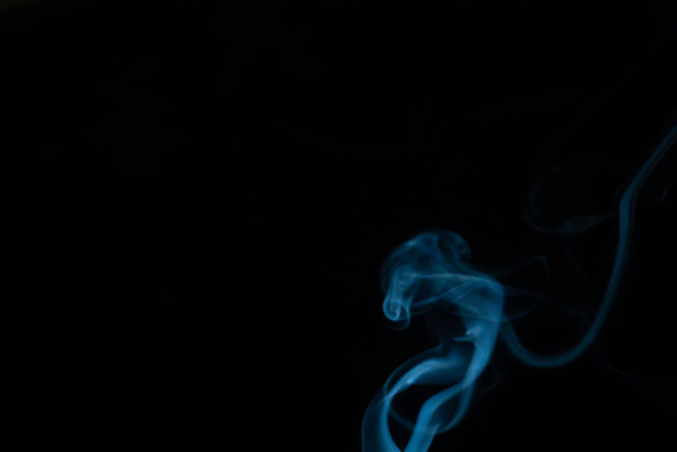 Beautiful abstract blue smoke with copy space on black background. Smoke background for art design or drawing. Abstract figure of the smoke - Фото, изображение
