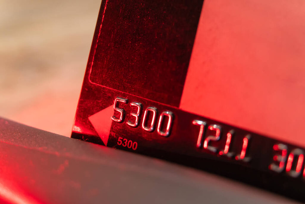 credit card is passed through the terminal in the light of red lights, macro - Photo, Image
