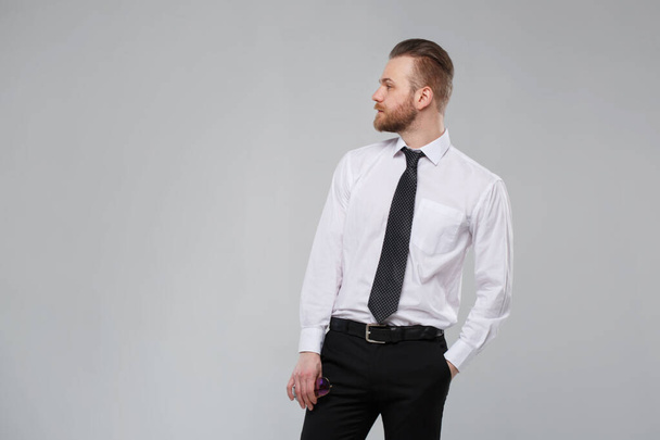 Stylish white man in casual office wear isolated on a gray background. - Photo, Image