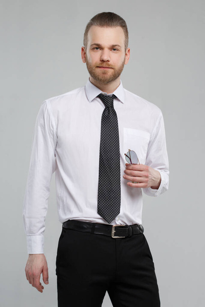 Stylish white man in casual office wear isolated on a gray background. - Zdjęcie, obraz