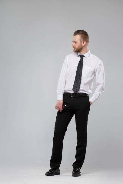 Stylish white man in casual office clothes in full growth isolated on a gray background. - Fotoğraf, Görsel