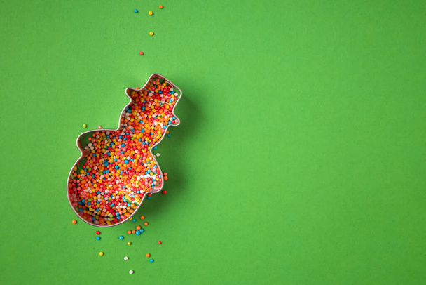 Christmas snowman shape form filled with colorful sugar sprinkles - Fotó, kép