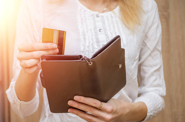 A nő kihúzza a kezét, vagy kivesz egy hitelkártyát a tárcájából. Fényképek jelzőrakétával. - Fotó, kép