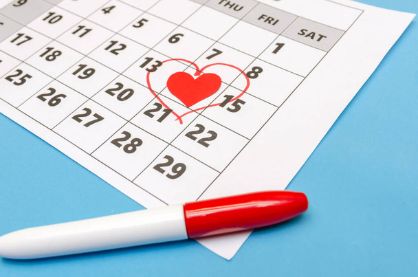 San Valentino 14 è segnato con un cuore sul calendario, cuori di carta e un pennarello sono sparsi in giro. Concetto vacanza - Foto, immagini