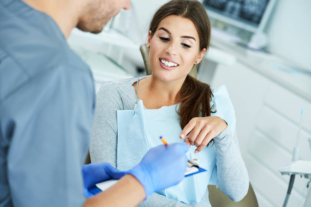Male dentist and woman in dentist office - Foto, imagen