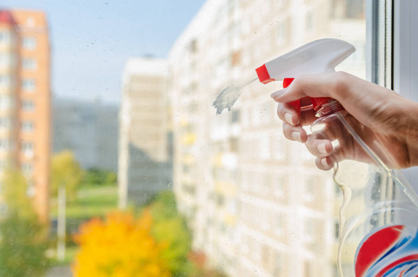 main de femme avec un moyen pour laver pyrskaet Windows sur la fenêtre et va le laver à l'automne Journée ensoleillée - Photo, image