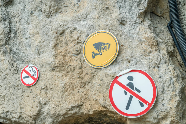 Tekenen op de rots "videobewaking", "geen doorgang", "niet roken"" - Foto, afbeelding