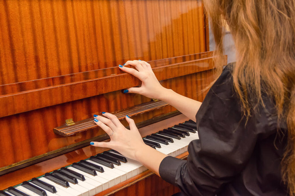 Піаністка відкриває кришку піаніно, щоб грати на ньому
 - Фото, зображення