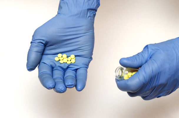 les pilules dans les mains en gants bleus - Photo, image