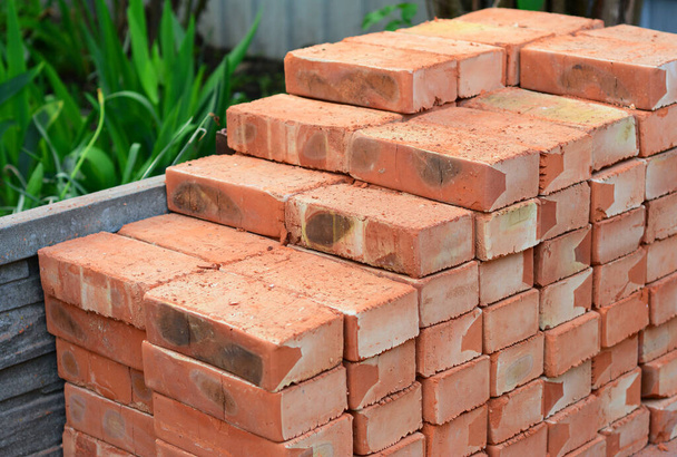 Uma pilha de materiais de construção, pilha de novos tijolos vermelhos para a construção são montados com precisão. - Foto, Imagem