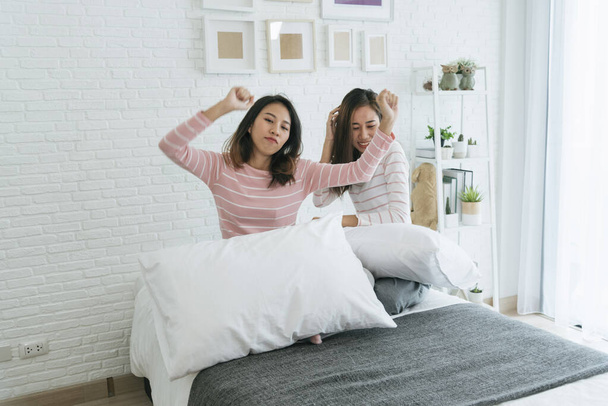 Two pretty best friends forever girlfriend talk, hug and laugh together on bed at cozy home relation fall in love. Lesbian couple homosexual happy lifestyle on bed. LGBTQ relation lifestyle concept. - Foto, Bild