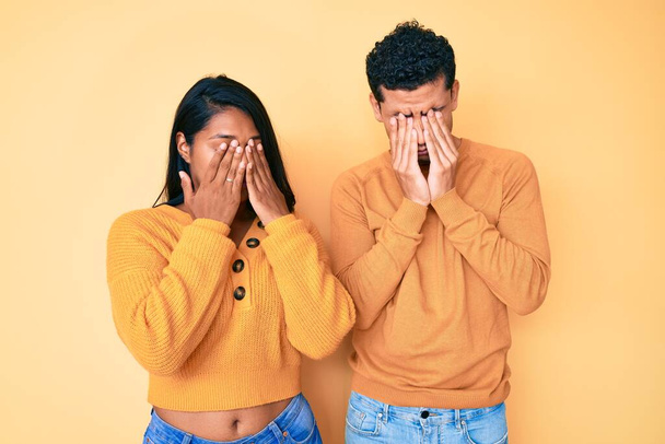 Beautiful latin young couple wearing casual clothes together rubbing eyes for fatigue and headache, sleepy and tired expression. vision problem  - Foto, Imagen