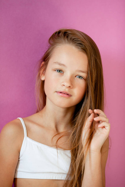 portrait of a gentle 9-year-old long-haired girl against a lilac wall - Foto, immagini