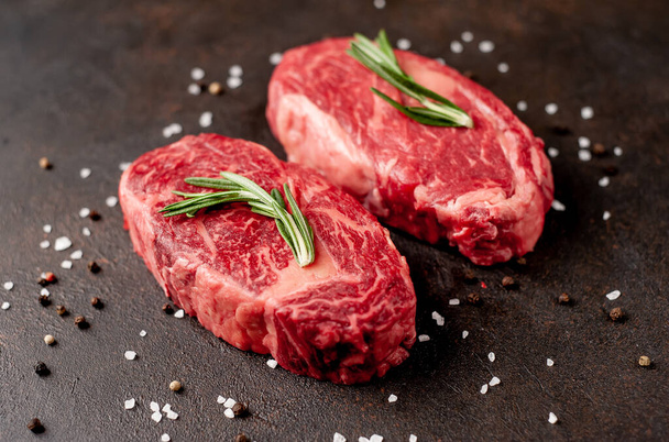 Dva syrové hovězí steaky s kořením na kamenném pozadí - Fotografie, Obrázek