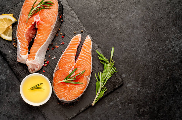 Raw fish salmon steaks with ingredients on a stone background - Foto, immagini
