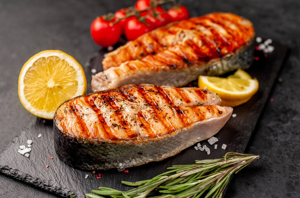 grilled salmon steaks with ingredients on a stone background - Photo, Image