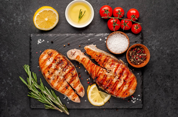 grilled salmon steaks with ingredients on a stone background - Foto, Imagem