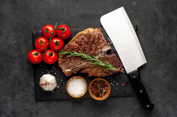 closeup view of yummy grill t-bone steak with ingredients on stone background - Photo, Image