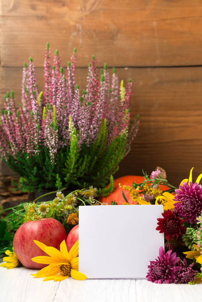 Composição de outono com flores, folhas, abóboras e cartão vazio branco no fundo de madeira. Conceito de outono para o dia de Ação de Graças ou para outros feriados. Espaço de cópia. - Foto, Imagem