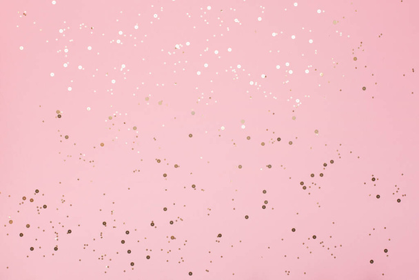 Golden sparkles and Many gold shiny glitter confetti on pink pastel trendy background. Festive backdrop for your projects. Abstract template - Fotó, kép