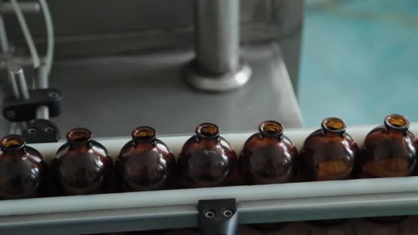 Kahverengi tıbbi şişeler bir uyuşturucu üretim tesisinde taşıyıcı bantta.. - Video, Çekim