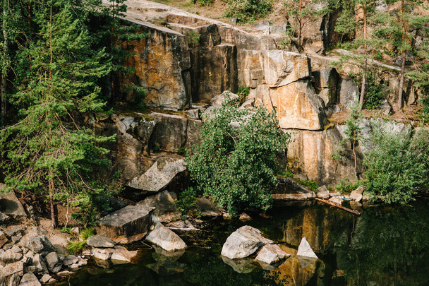 Landscape of an old flooded industrial granite quarry filled with water. Lake on the background of rocks and fir trees. Canyon. The nature of autumn. Place for text and design. - Φωτογραφία, εικόνα