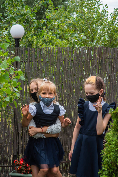 マスクをした3人の女子学生は、流行期に学校に戻ります。保護マスクをした女子高生3人。ウイルス細菌学校保護などです。ティーン女の子で学校制服 - 写真・画像