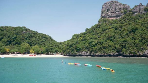 Islands in ocean at Ang Thong National Marine Park near touristic Samui paradise tropical resort. Idyllic turquoise sea natural background with copy space. Kayaks and colorfull sports canoes. - Photo, Image