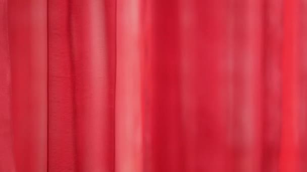 Transparent window curtain, gently moved by the wind. Smooth waves of red matter develops from the wind. Conceptual romantic decorationgently moving background. Decorative red stripes, waving gently - Footage, Video