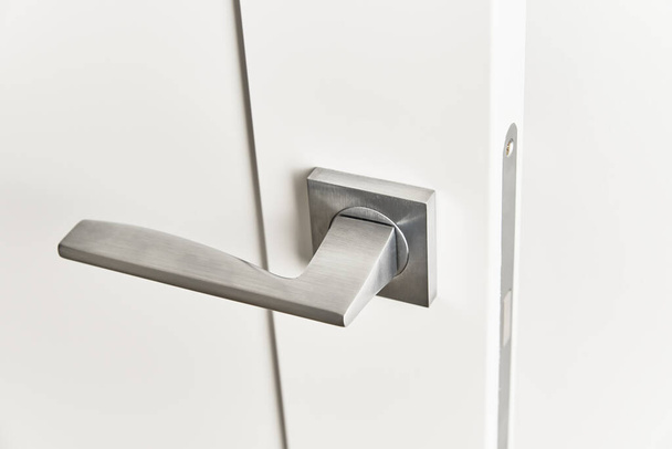 Silver door handle on white door.  Furniture accesories, interior element - Foto, Imagen
