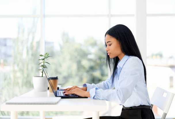 Pretty black businesswoman working working with laptop in modern office - Photo, Image