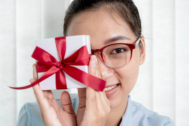 Asiatin im Geschenkkarton Froh, an Feiertagen, Weihnachten, Geburtstagen oder Valentinstagen mit Begeisterung, Freude und Lächeln überrascht zu sein. - Foto, Bild