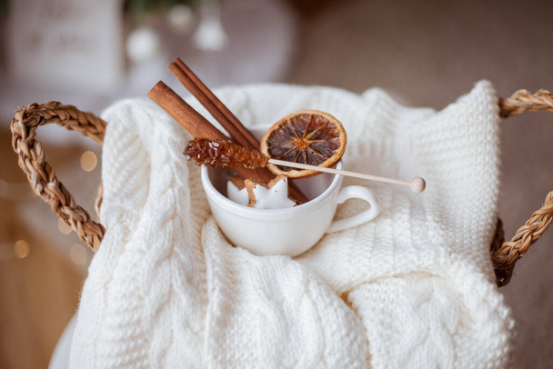 wicker basket, knitted sweater, dried citruses, cinnamon sticks, Christmas cookies, Christmas lights. Cozy. Winter. - Photo, Image