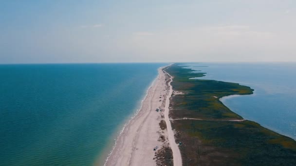 Luchtfoto drone beelden van strand en zee versplinterd door zandkust. Landschappelijk panorama van de kust met wit zandstrand en groene gebieden.  - Video