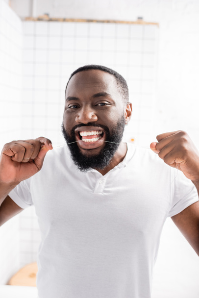 retrato del hombre afroamericano usando hilo dental - Foto, Imagen