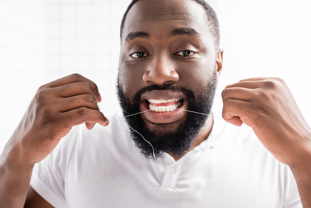 portré afro-amerikai férfiról fogselyemmel és kamerával - Fotó, kép