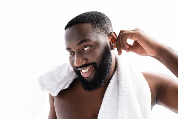 ritratto di uomo afro-americano pulizia orecchie e occhi rotolanti - Foto, immagini